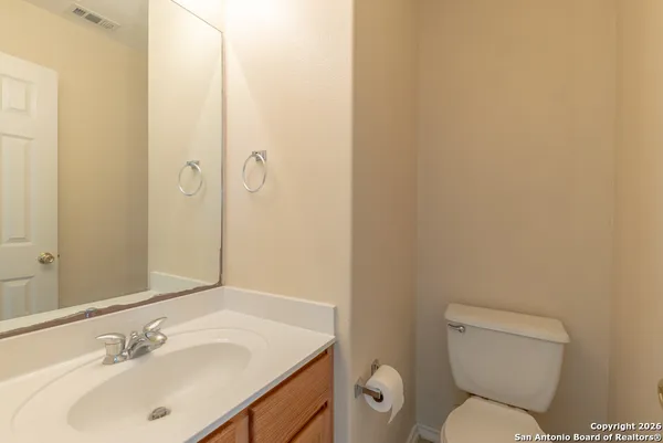 a bathroom with a toilet sink vanity and mirror