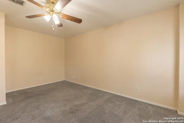 an empty room with a fan and a fan