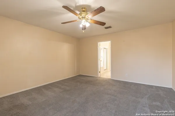 an empty room with windows and fan