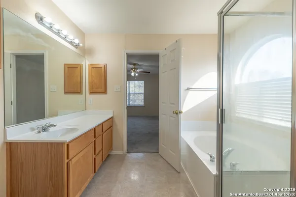 a bathroom with a tub a sink and mirror