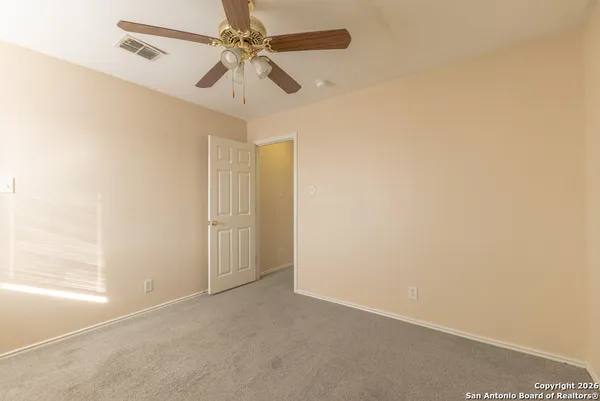an empty room with a ceiling fan and a window