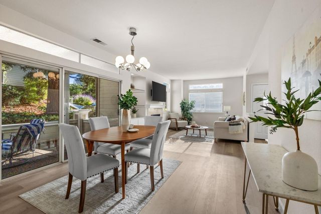 a view of a dining room with furniture a chandelier and wooden floor