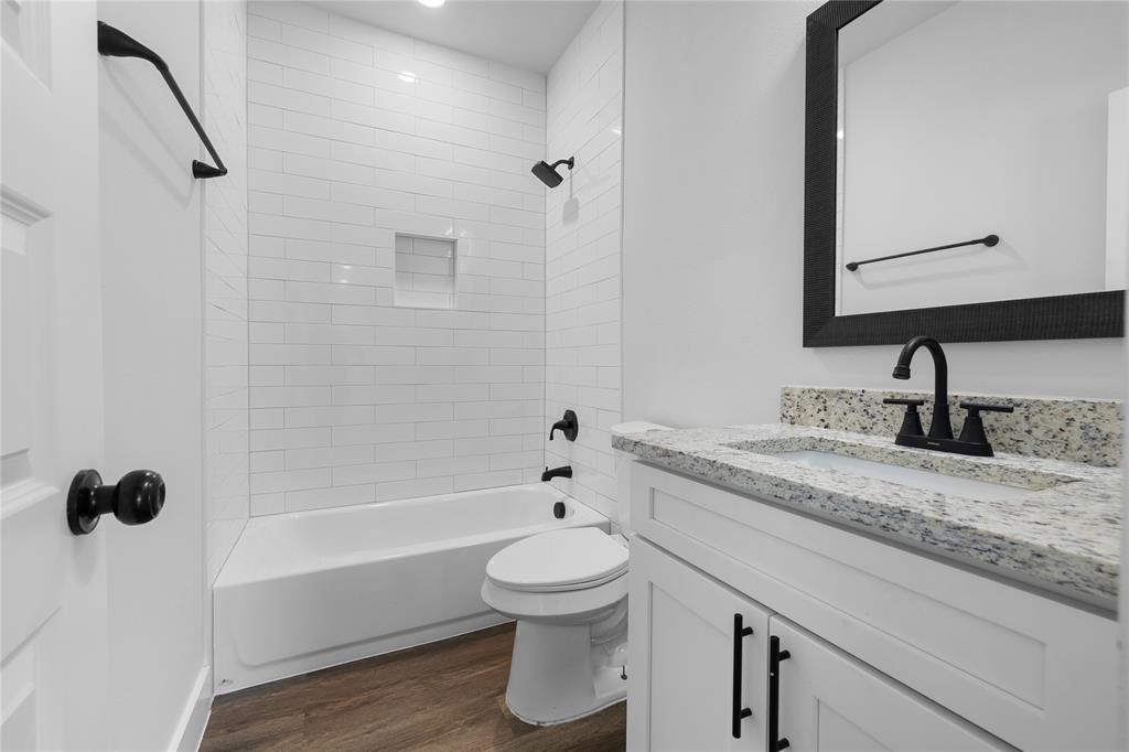 120 Red Bird Lane Mabank, TX 75156 - Photo 11 of 23 a bathroom with a granite countertop sink toilet a bathtub and a shower