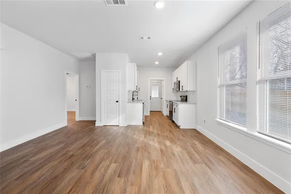 a view of a kitchen with wooden floor and windows