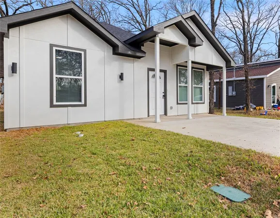 a front view of a house with a yard outdoor seating and garage