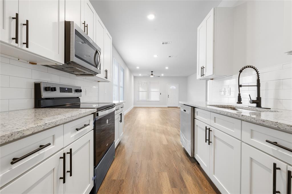 120 Red Bird Lane Mabank, TX 75156 - Photo 18 of 23 a large kitchen with stainless steel appliances granite countertop a lot of counter space and wooden floors
