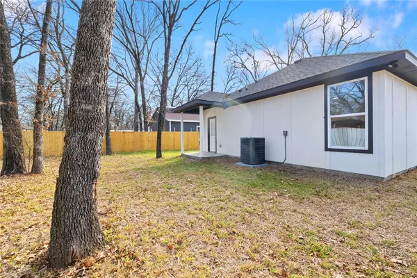 a view of a house with a large tree and wooden fence