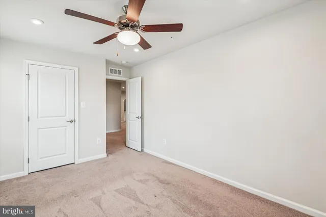 an empty room with a ceiling fan and a chandelier fan