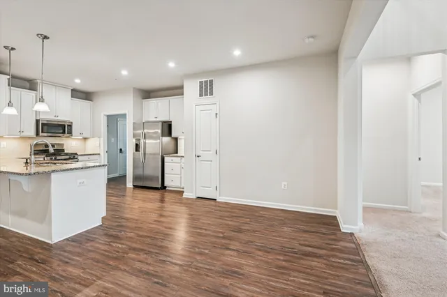 a view of kitchen with refrigerator microwave and stove