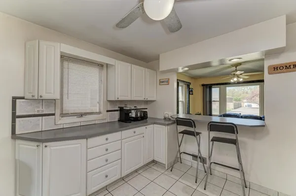 a kitchen with granite countertop white cabinets and white appliances