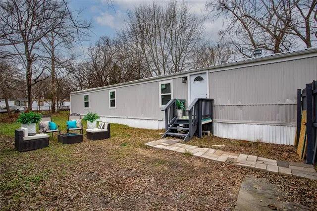 a view of a backyard with large tree and wooden fence