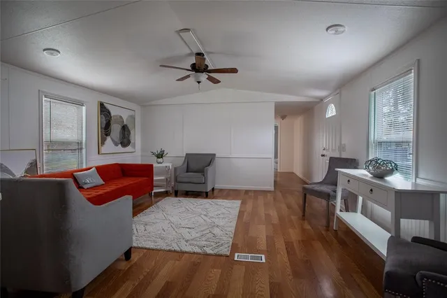 a living room with furniture and a wooden floor