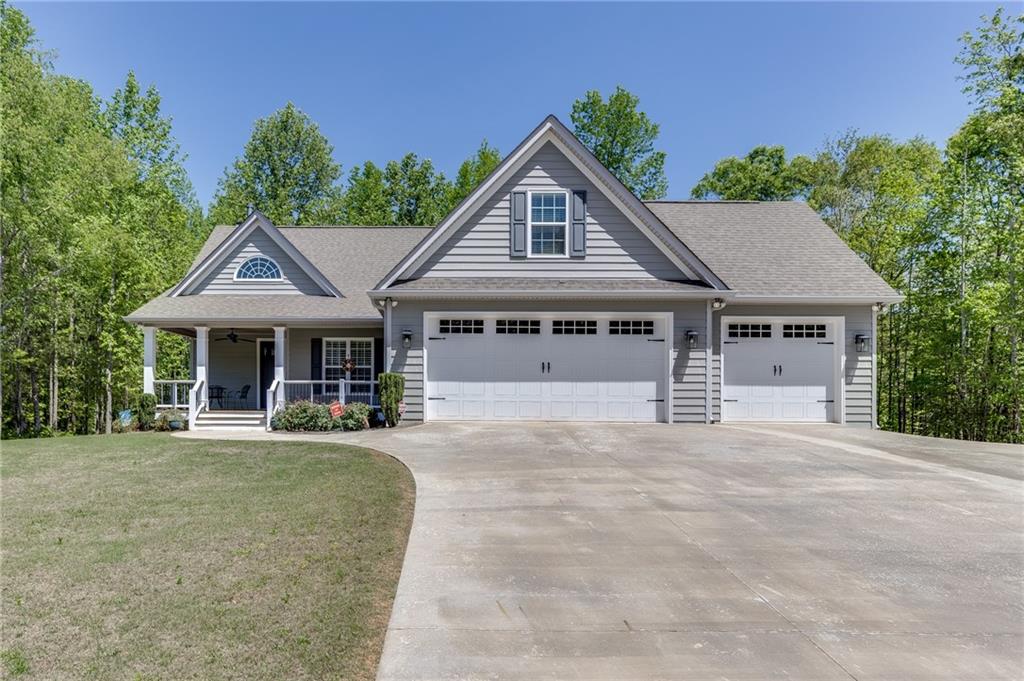 a front view of a house with yard and green space
