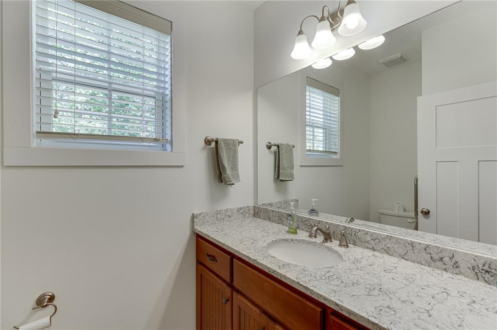 7660 Fern Lane Lula, GA 30554 - Photo 6 of 50 a bathroom with a granite countertop sink a large mirror and a window