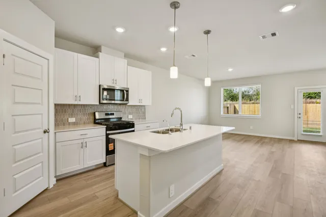 a kitchen with a sink appliances and cabinets