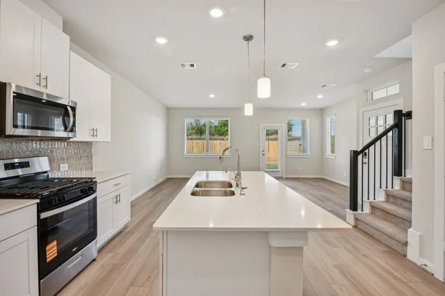 a kitchen with kitchen island white cabinets and stainless steel appliances