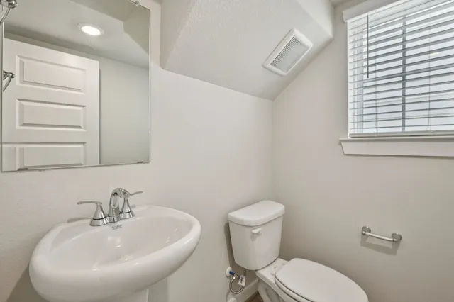 a bathroom with a sink a toilet and mirror