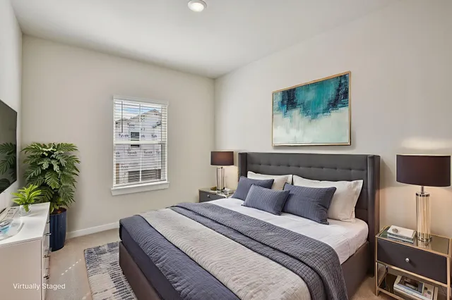 a bedroom with bed and a potted plant