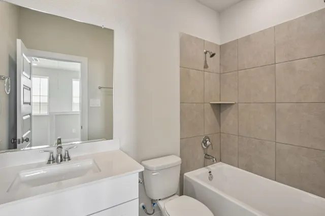 a bathroom with a sink mirror toilet and bathtub