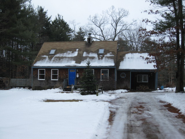 a front view of a house with a yard covered in snow
