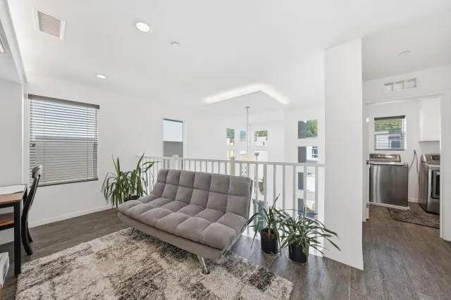 a living room with a bed furniture and a large window