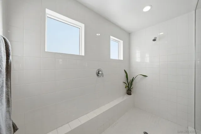 a kitchen with stainless steel appliances granite countertop a stove top oven a refrigerator a sink and white cabinets with wooden floor