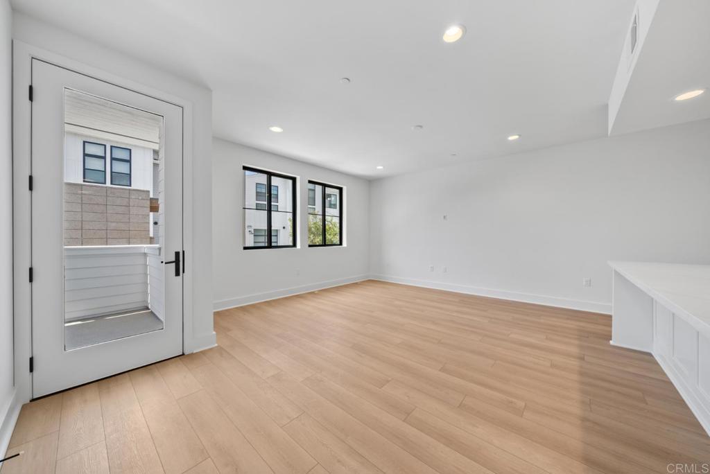 1101 Catania, Unit 104 Encinitas, CA 92024 - Photo 11 of 41 an empty room with wooden floor and windows