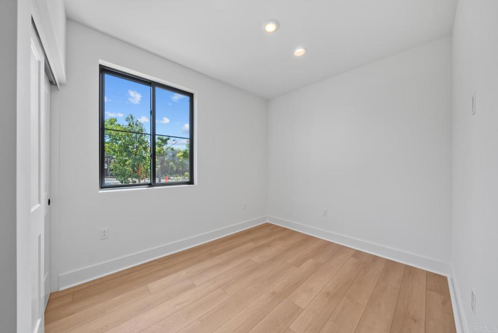 1101 Catania, Unit 104 Encinitas, CA 92024 - Photo 15 of 41 a view of an empty room with wooden floor and a window