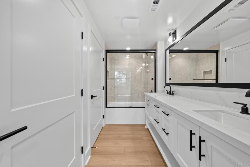 1101 Catania, Unit 104 Encinitas, CA 92024 - Photo 21 of 41 a bathroom with a double vanity sink and mirror with shower