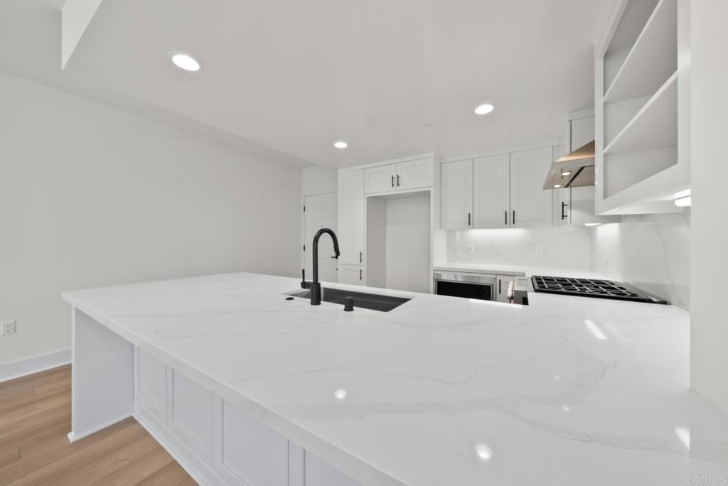 1101 Catania, Unit 104 Encinitas, CA 92024 - Photo 24 of 41 a kitchen with stainless steel appliances and white cabinets