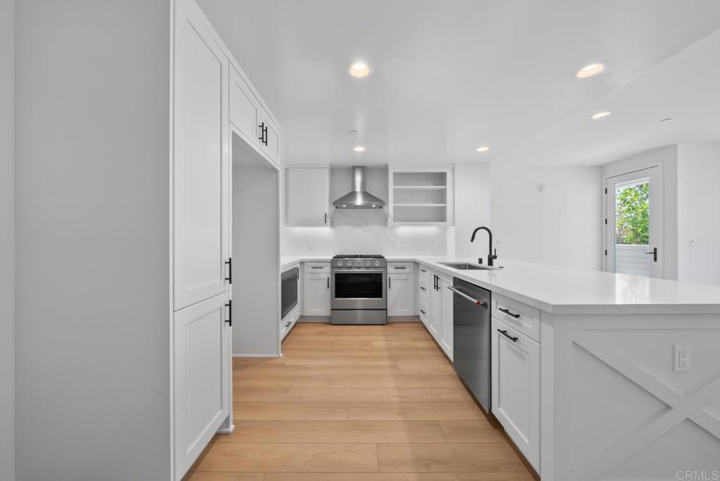 1101 Catania, Unit 104 Encinitas, CA 92024 - Photo 5 of 41 a large kitchen with stainless steel appliances granite countertop a stove and a sink