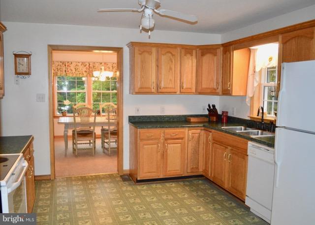 1450 Stringtown Road Berryville, VA 22611 - Photo 4 of 13 a kitchen with stainless steel appliances granite countertop a refrigerator a sink a stove and white cabinets with wooden floor