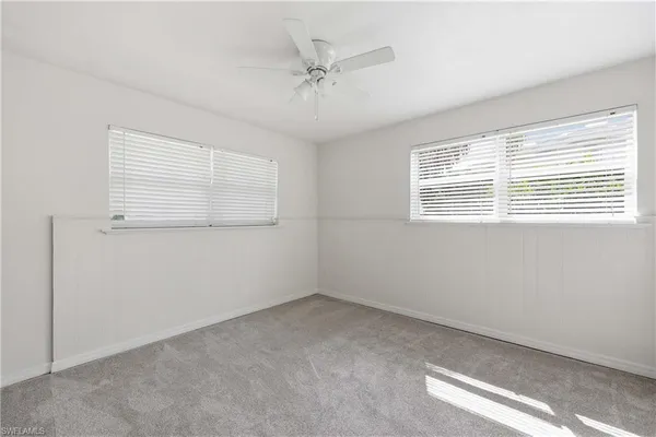 an empty room with a window and a ceiling fan