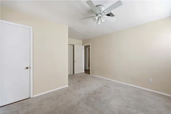 an empty room with fan and a ceiling fan