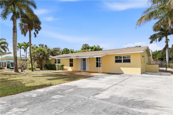 front view of a house with a yard and potted plants