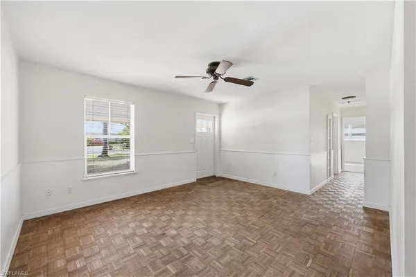 an empty room with fan and windows