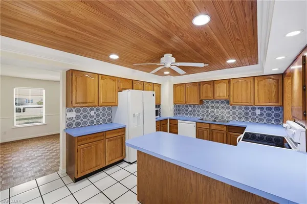 a kitchen with stainless steel appliances kitchen island granite countertop a refrigerator and a stove