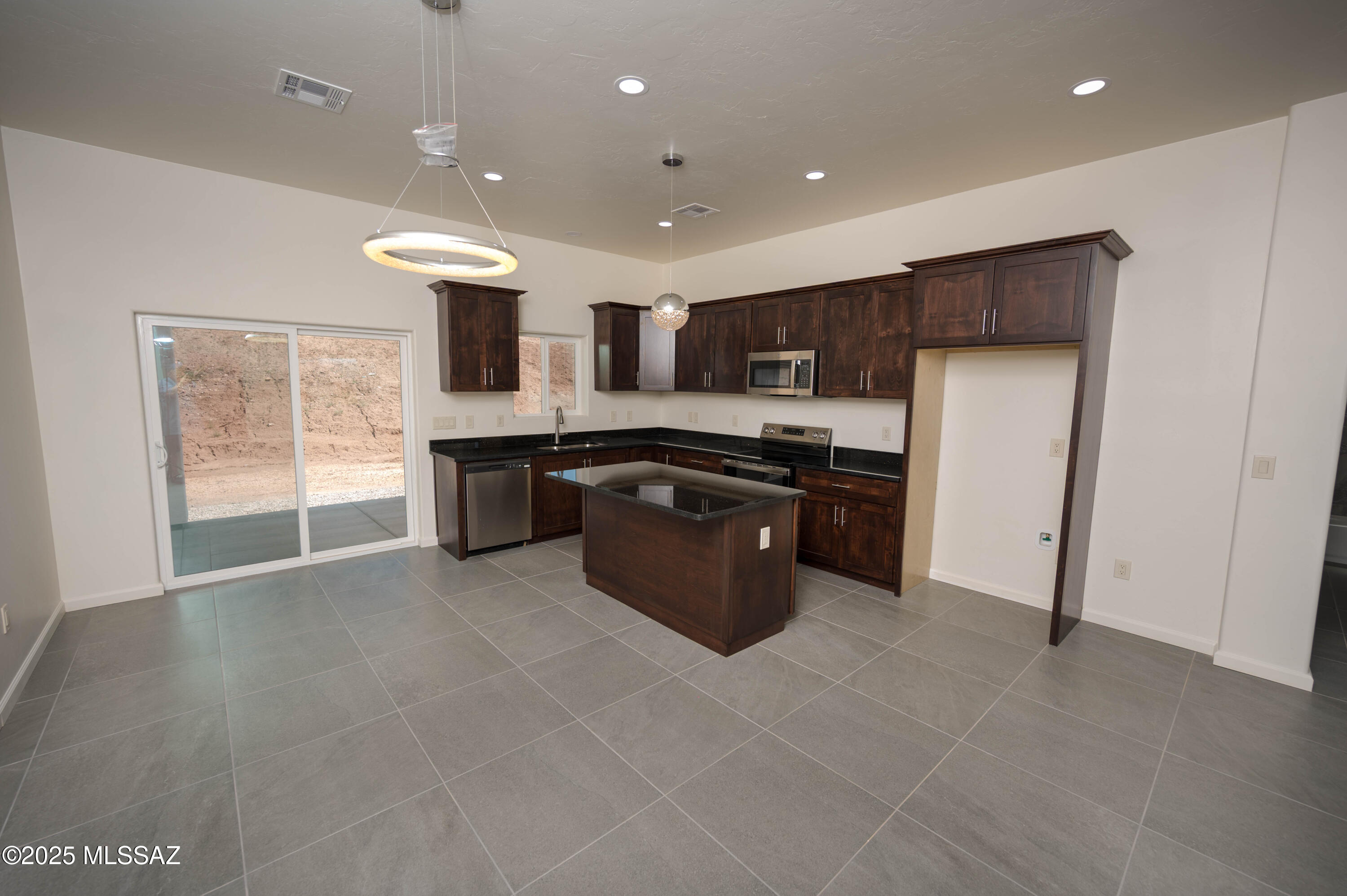 280 Donna Court Rio Rico, AZ 85648 - Photo 18 of 50 a large kitchen with stainless steel appliances granite countertop a stove a sink and a refrigerator