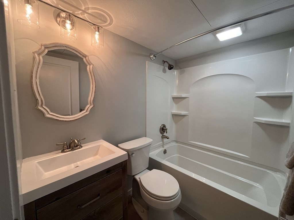 70 Southbridge Street, Unit 215 Worcester, MA 01608 - Photo 14 of 27 a bathroom with a sink a toilet and a mirror