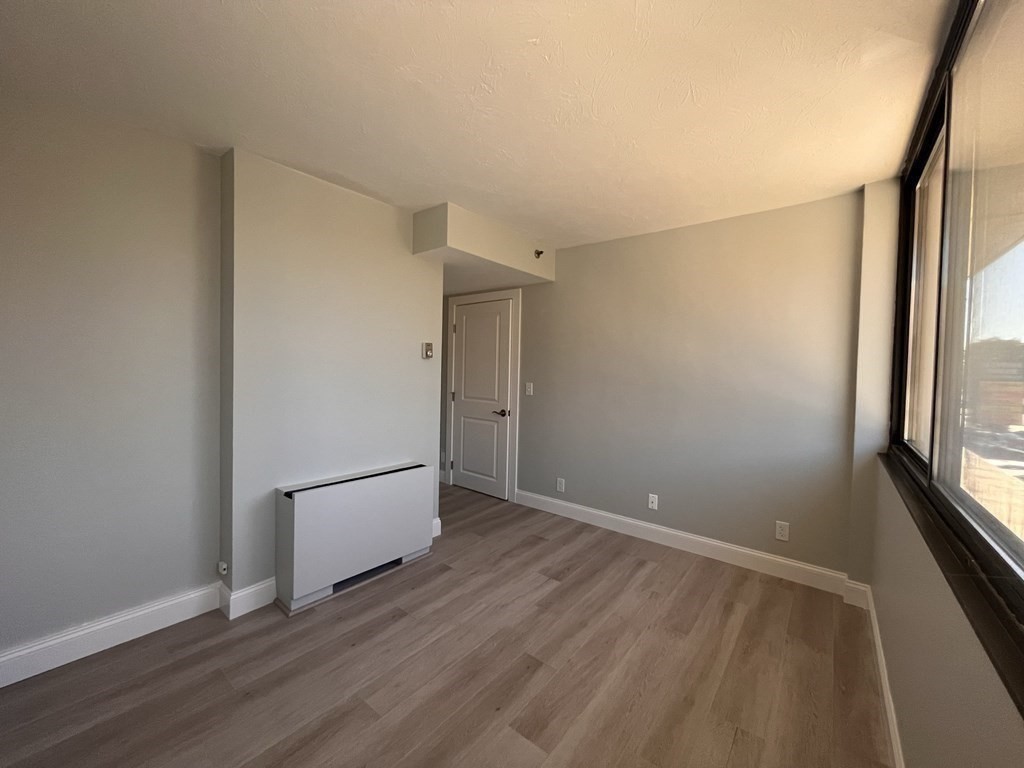 70 Southbridge Street, Unit 215 Worcester, MA 01608 - Photo 19 of 27 a view of an empty room with wooden floor and a window