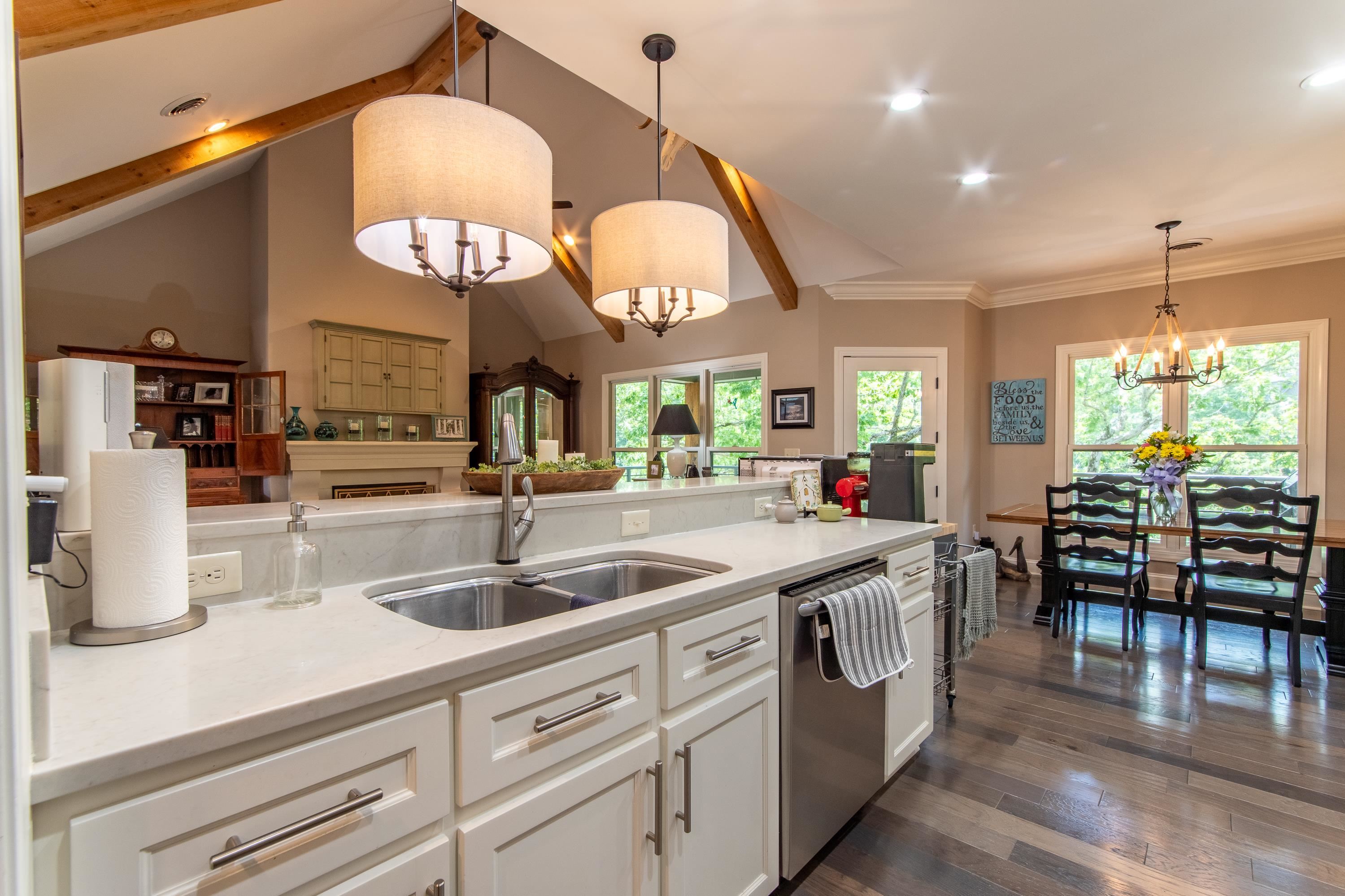 55 Ridge Pointe Drive Savannah, TN 38372 - Photo 2 of 40 Kitchen with decorative light fixtures, stainless steel dishwasher, white cabinetry, vaulted ceiling with beams, and dark hardwood / wood-style floors