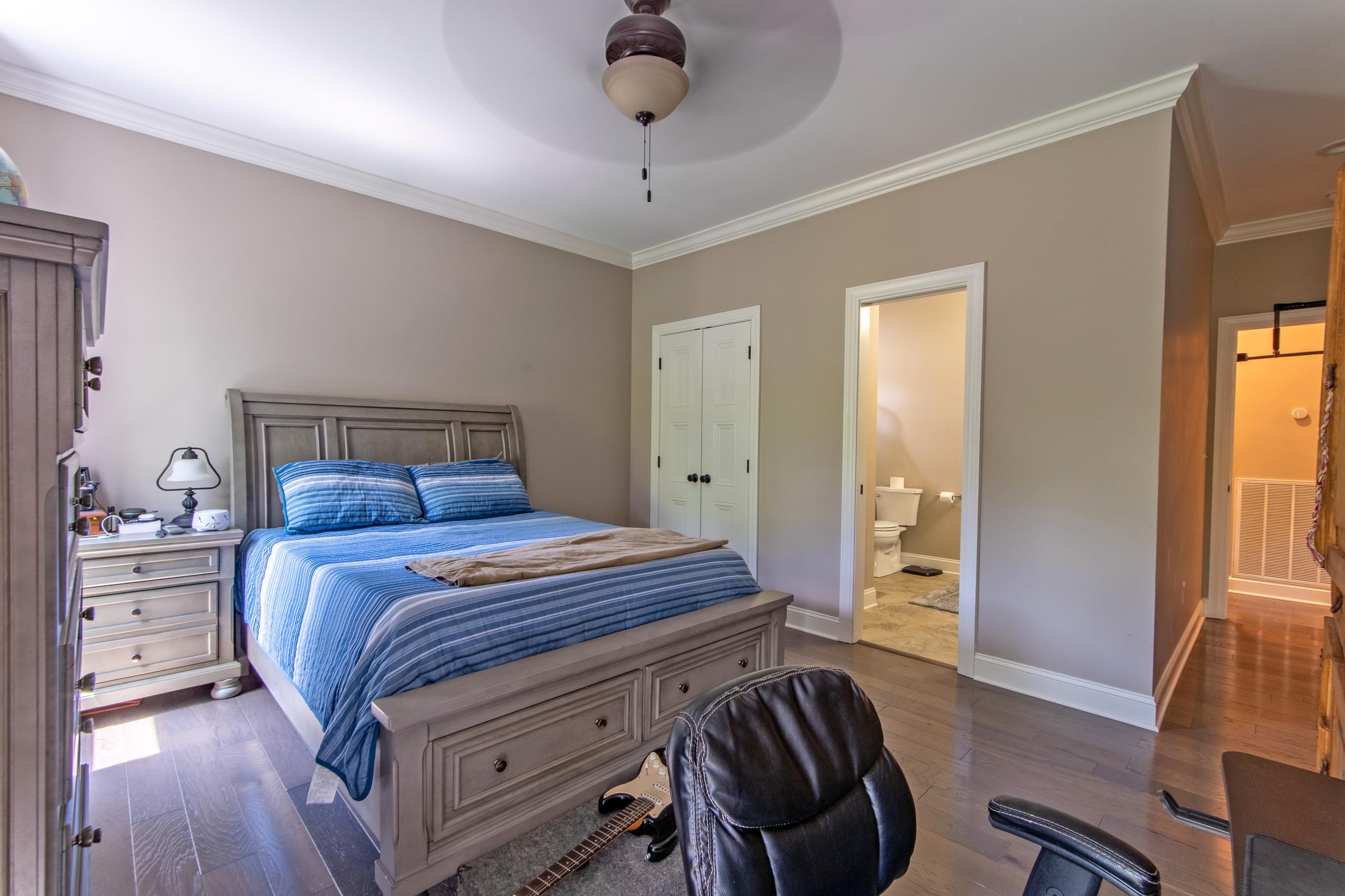 55 Ridge Pointe Drive Savannah, TN 38372 - Photo 21 of 40 Bedroom featuring crown molding, ceiling fan, dark hardwood / wood-style floors, ensuite bathroom, and a closet