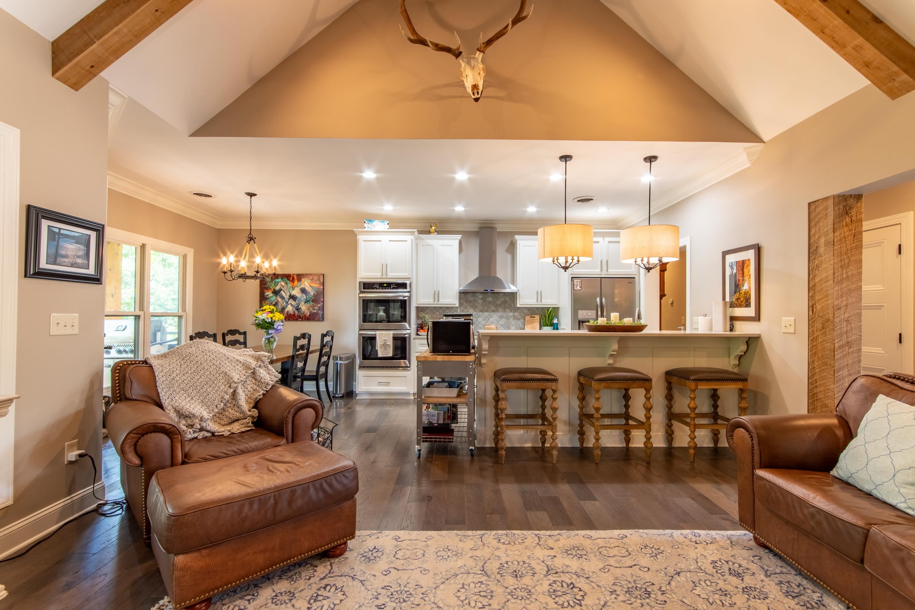 55 Ridge Pointe Drive Savannah, TN 38372 - Photo 7 of 40 Living room featuring a notable chandelier, lofted ceiling with beams, crown molding, and dark wood-type flooring