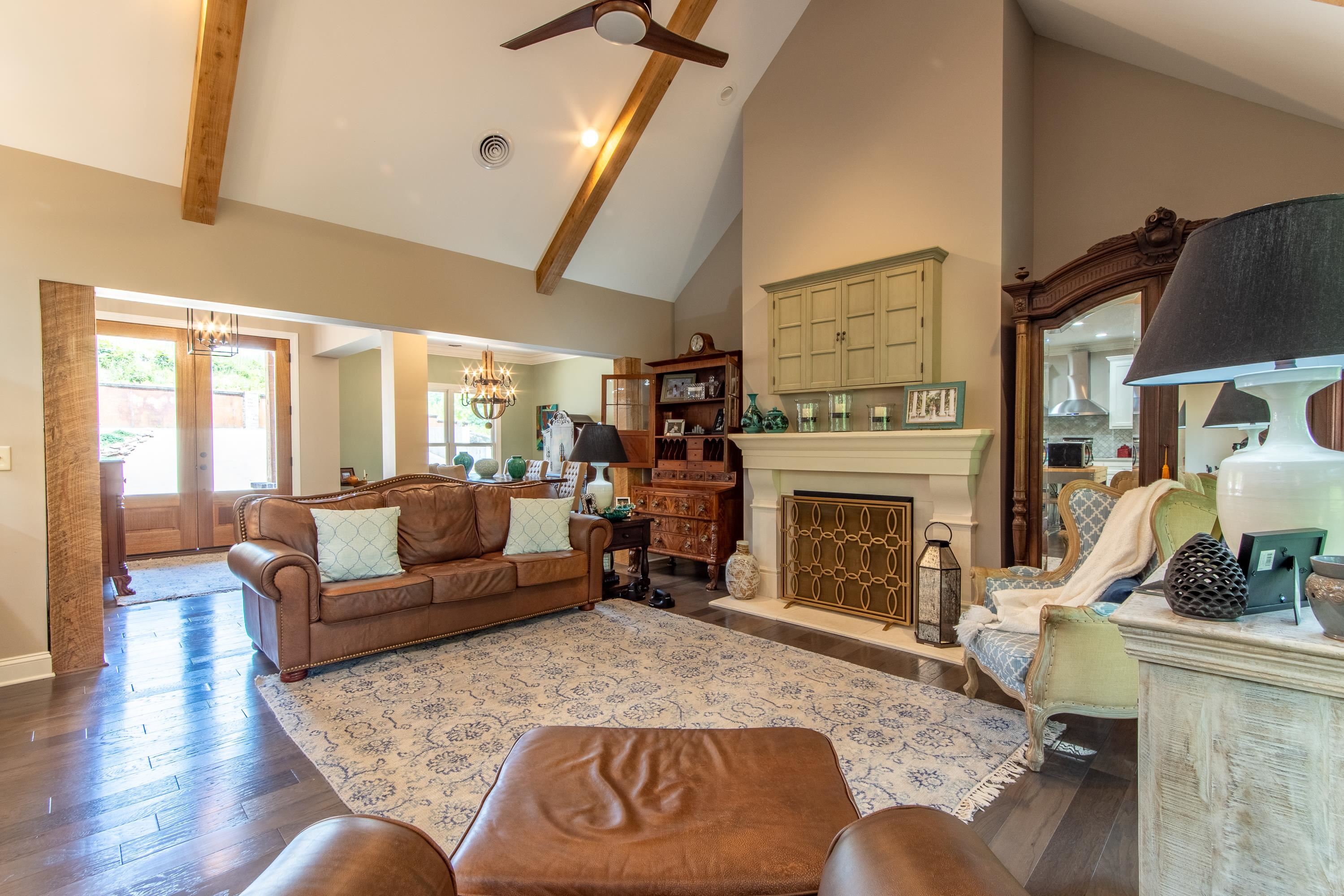 55 Ridge Pointe Drive Savannah, TN 38372 - Photo 10 of 40 Living room with ceiling fan with notable chandelier, high vaulted ceiling, beam ceiling, french doors, and dark wood-type flooring