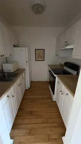 a kitchen with granite countertop white cabinets and black appliances