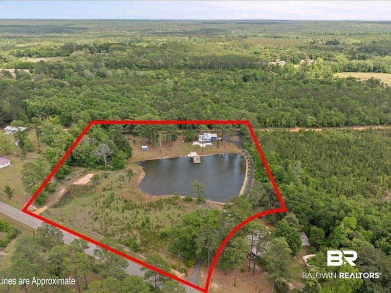 3160 Old Castleberry Road Brewton, AL 36426 - Photo 3 of 36 Expansive acreage featuring a private pond with a dock, surrounded by mature trees