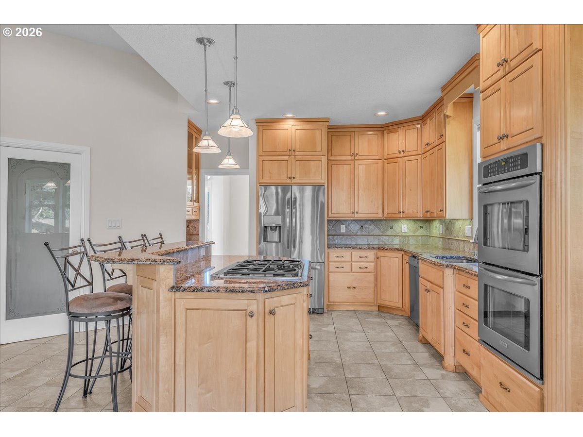 34043 Bennett Road Warren, OR 97053 - Photo 18 of 46 a kitchen with stainless steel appliances kitchen island granite countertop a stove a sink dishwasher and a refrigerator