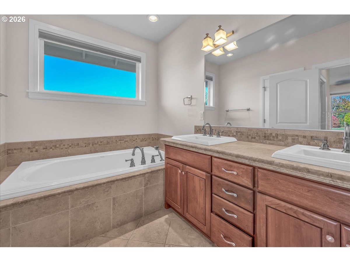 34043 Bennett Road Warren, OR 97053 - Photo 32 of 46 a bathroom with a tub a double vanity sink and a mirror