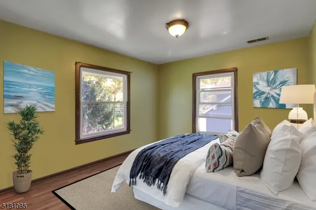 a bedroom with a bed and painting on the wall