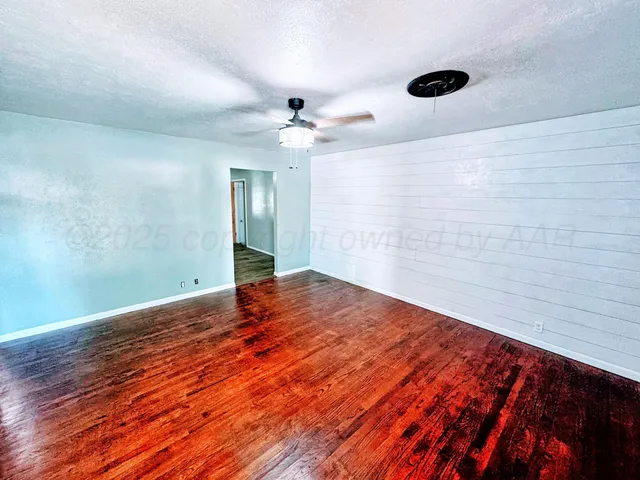 a view of empty room with wooden floor